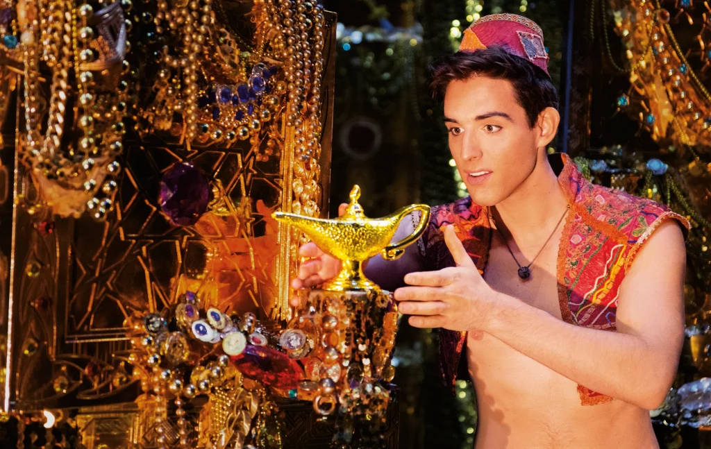 Aladdin Musical Stuttgart - staunender Aladdin findet die goldene Wunderlampe in einem Meer aus Schätzen