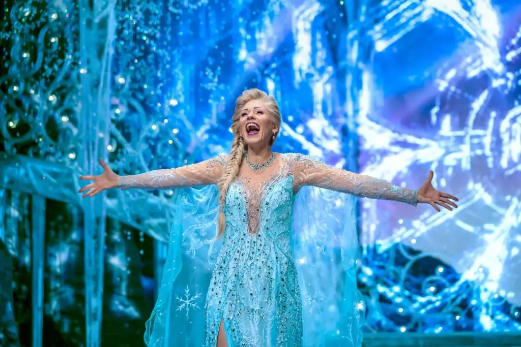 Die Eiskönigin Musical in Hamburg – Elsa im Eispalast im langen Kristallkleid vor großer Freitreppe und Bögen aus Eiskristall